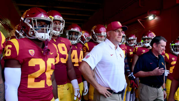 Clay Helton standing with his USC football players in the tunnel before a game.