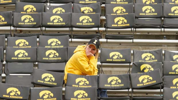 An Iowa fan sitting by herself before a football game.