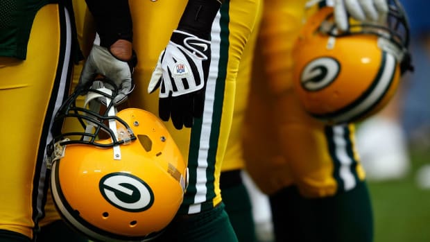 A view of Green Bay Packers players holding their helmets.