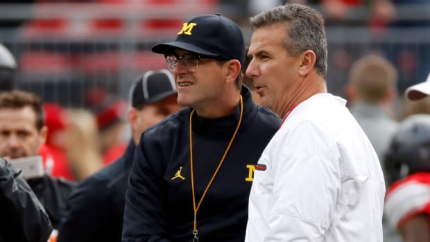 Head coach Urban Meyer of the Ohio State Buckeyes and Head coach Jim Harbaugh of the Michigan Wolverines talk on the field prior to their game.