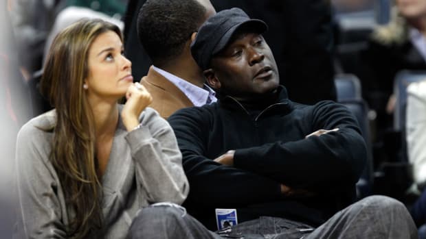 Michael Jordan and his wife sitting courtside.