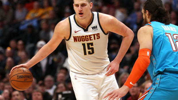 Denver Nuggets NBA star Nikola Jokic dribbling the basketball.
