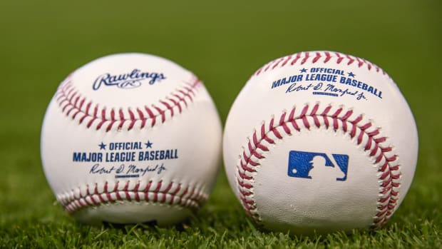A generic photo of two baseball's sitting side-by-side on a field.