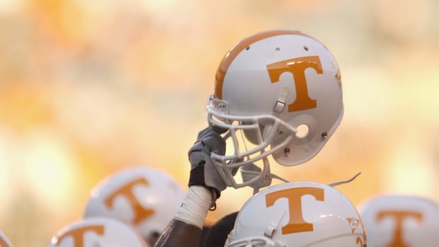 A Tennessee football player holding up his helmet before a game.