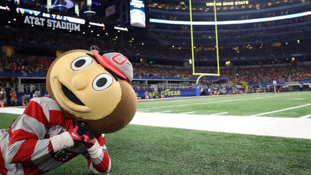 Ohio State's mascot laying on the field during a football game.