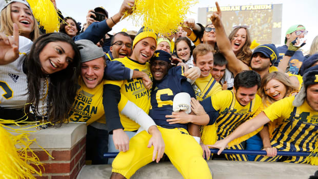 Michigan star Denard Robinson celebrates with Wolverines fans.