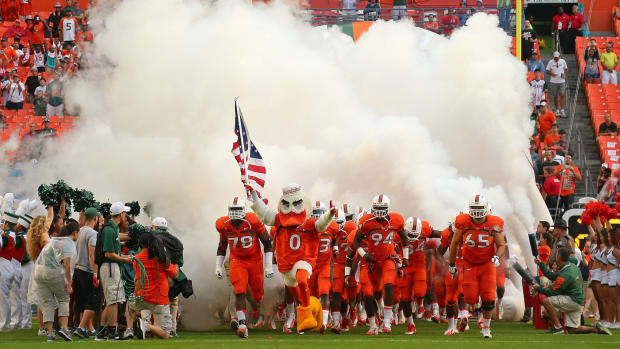Miami players running on the field for a game.