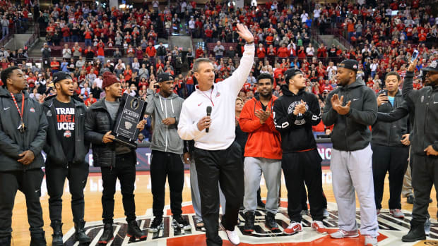 Urban Meyer and Ohio State football at center court during OSU basketball game.