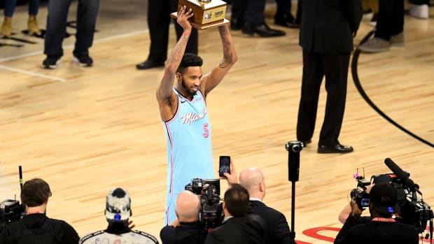 Miami Heat wing Derrick Jones Jr. hoists NBA Dunk Contest trophy.