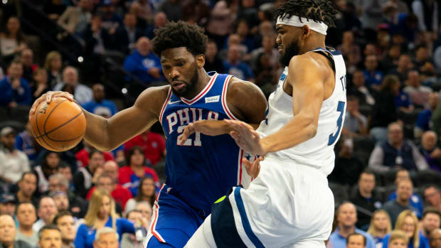 Joel Embiid tries to drive on Karl-Anthony Towns in an NBA game.
