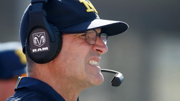 Jim Harbaugh winces as he looks on from the sideline.