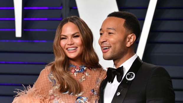 John Legend posing for a photo with his wife Chrissy Teigen.