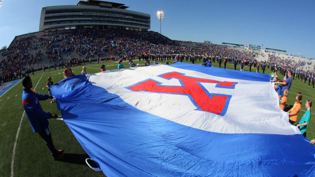 Fans hold a University of Kansas school flag during the playing of the nation anthem prior to a game.