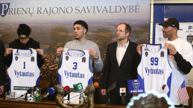 LaVar, LiAngelo and LaMelo Ball holding up with Vytautas uniforms.