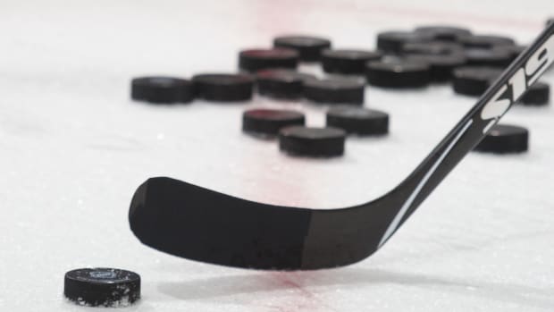 A generic photo of a hockey puck and hockey stick.