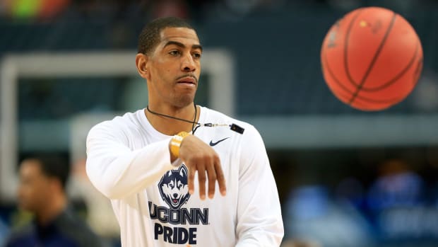 Kevin Ollie passing the basketball during a practice.