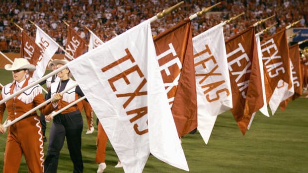 Texas Longhorns cheerleaders holding flags.