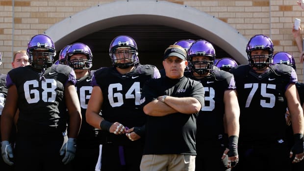 Gary Patterson leading his TCU football team onto the field for a Big 12 football game.