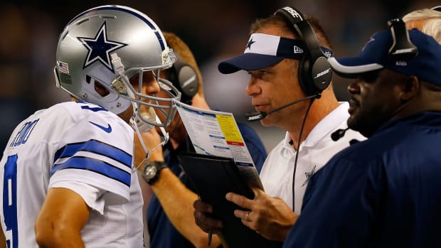 Dallas Cowboys offensive coordinator Scott Linehan speaks with Tony Romo during a game.