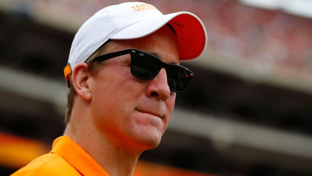 Peyton Manning in a Tennessee hat watching a game.