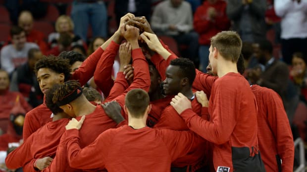 Louisville basketball's players huddle up before a game.