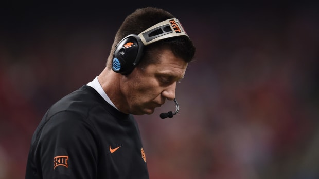 Mike Gundy with his head down on the sidelines.