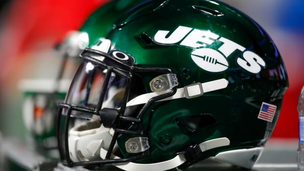 A picture of two Jets helmets sitting side-by-side.