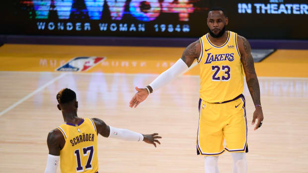 LeBron James daps up new Los Angeles Lakers teammate Dennis Schroder during early 2020-21 game.