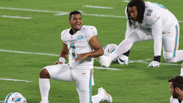 Tua Tagovailoa stretches on the field before a Miami Dolphins game.