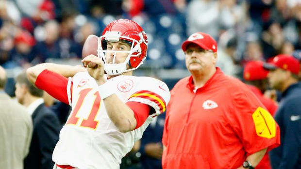 Alex Smith throws the ball before a game while Andy Reid looks on.