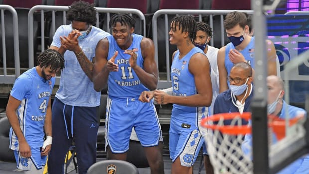 North Carolina players celebrate on the bench during a game.