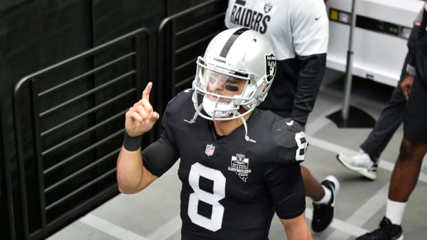 Raiders quarterback Marcus Mariota points to the sky while walking.