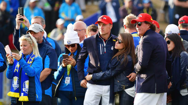 Jordan Spieth standing with his wife on the golf course.