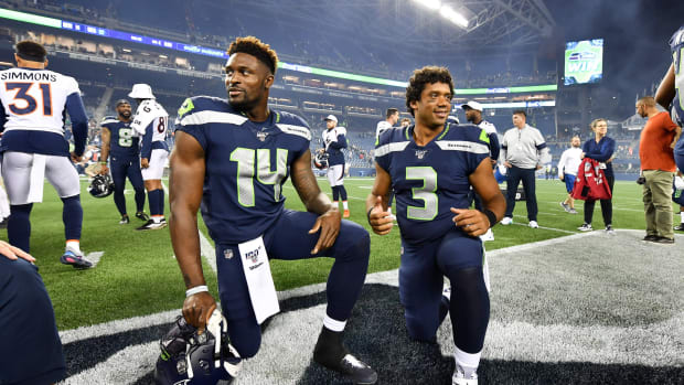D.K. Metcalf #14 and Russell Wilson #3 of the Seattle Seahawks take a knee