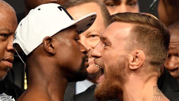 Conor McGregor and Floyd Mayweather standing face to face.