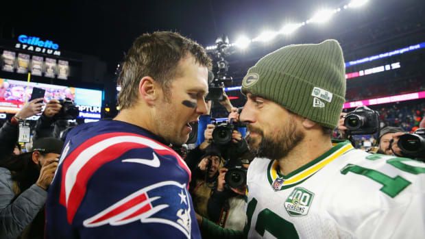 Superstar quarterbacks Tom Brady and Aaron Rodgers talk after a game.
