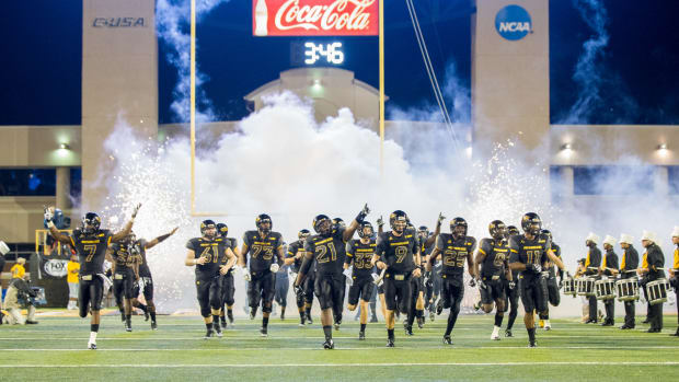 Southern Miss football players run out onto field.