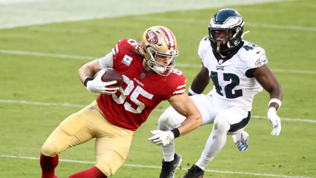 George Kittle runs with the ball for the 49ers.