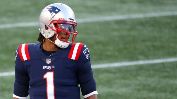 New England Patriots quarterback Cam Newton looks down the field.