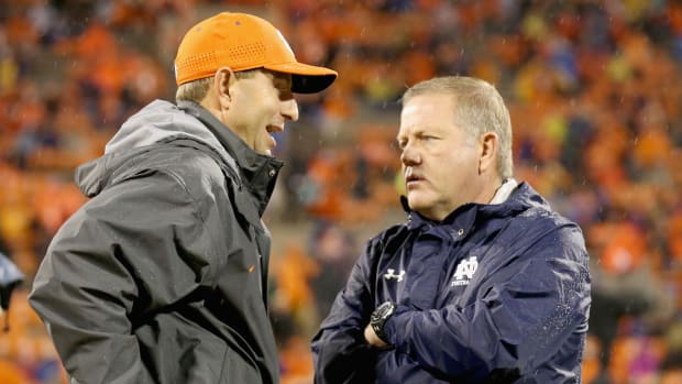 Clemson coach Dabo Swinney talks with Notre Dame coach Brian Kelly ahead of a regular season college football game.