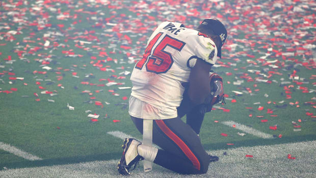Devin White #45 of the Tampa Bay Buccaneers takes a moment to himself on a knee after winning Super Bowl LV