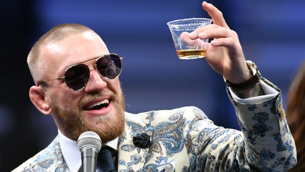 Conor McGregor raising a glass of Whiskey.