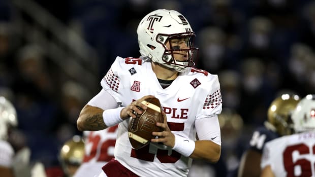 Temple quarterback Anthony Russo holds the football while running.