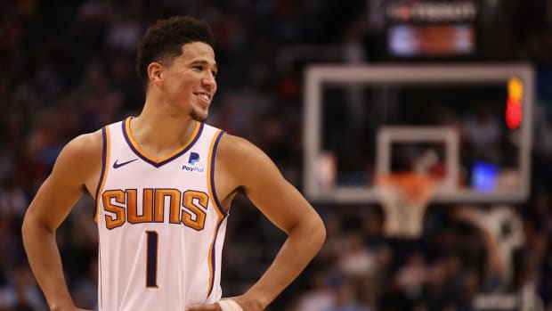 A closeup of Devin Booker smiling during a game.