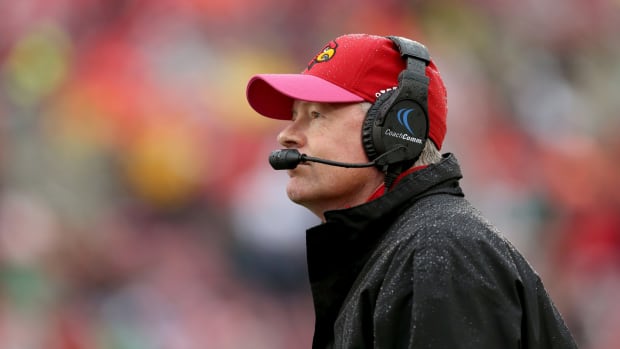 Bobby Petrino wearing a headset on the field for the Cardinals.