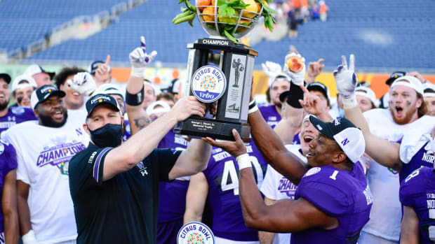 Head coach Pat Fitzgerald and Jesse Brown #1 of the Northwestern Wildcats raise the Citrus Bowl trophy