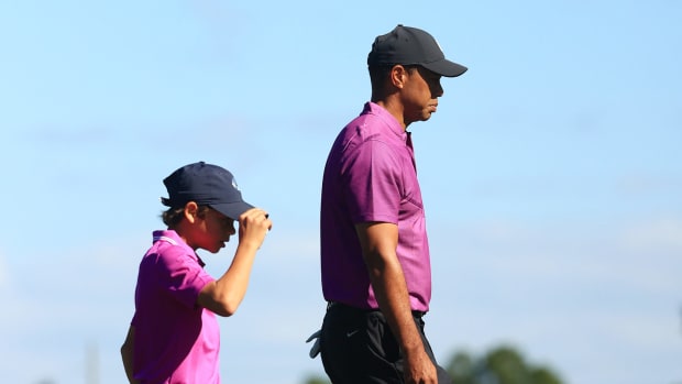 Charlie and Tiger Woods walk together.