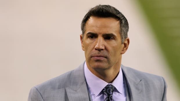 Kurt Warner in a suit on the field before the Super Bowl.