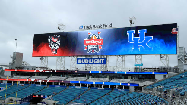 Signage is displayed for TaxSlayer Gator Bowl game between the Kentucky Wildcats and the NC State Wolfpack