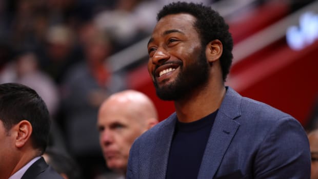 John Wall sits on the bench during a game.